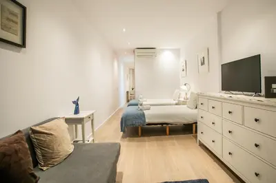 a bedroom with a bed and a dresser with a tv at E4lle1031 - Studio next to Plaza Espanya in Barcelona