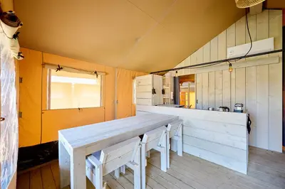 a bunk bed in a room with a ladder at Glamping Costa Dorada in Vilanova i la Geltrú