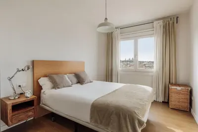 a kitchen with white cabinets and a wooden table at Ola Living Sant Antoni Market in Barcelona