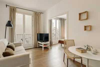 a kitchen and dining room with a white table and chairs at Ola Living Sant Antoni Market in Barcelona