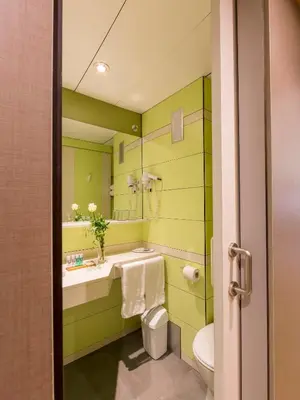 a green bathroom with a sink and a toilet at Bonanova Suite in Barcelona