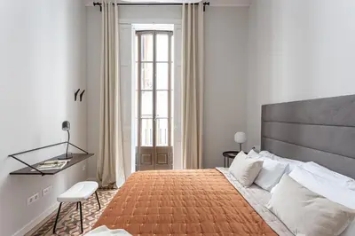a bedroom with a large bed and a desk at Serra house premium apartments in Barcelona