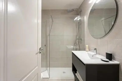 a bathroom with a sink and a shower with a mirror at Serra house premium apartments in Barcelona