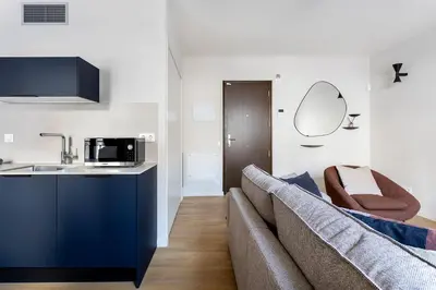 a living room with a couch and a kitchen at Serra house premium apartments in Barcelona