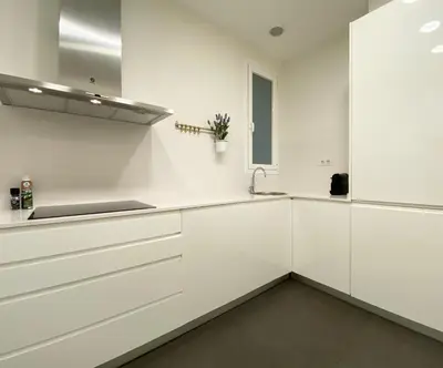 a white kitchen with white cabinets and a sink at Spacious Elegant on Avenue Diagonal By MyRentalHost in Barcelona