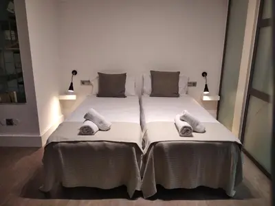 a bedroom with two beds with pillows on them at ApartEasy - MONUMENT, large, cosy apartment in Barcelona