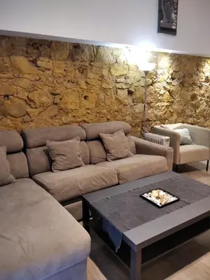 a living room with a couch and a stone wall at ApartEasy - MONUMENT, large, cosy apartment in Barcelona