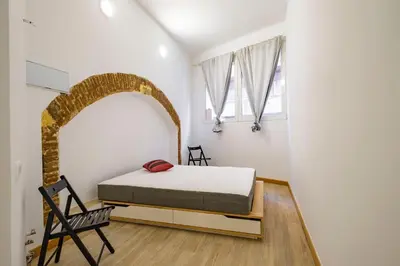 a bedroom with a bed and a chair and a window at BRAND NEW Pl Espana Sants Fira Apartment 2024 Built, Aplus, AirCon & Heating, Gigabit WiFi, Parking in Barcelona