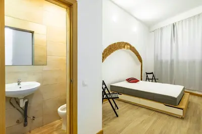 a bedroom with a bed and a sink and a mirror at BRAND NEW Pl Espana Sants Fira Apartment 2024 Built, Aplus, AirCon & Heating, Gigabit WiFi, Parking in Barcelona