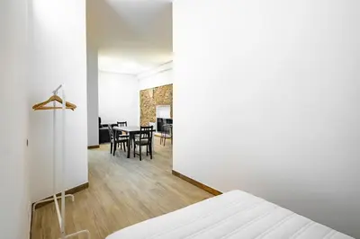 a bedroom with a bed and a dining room at BRAND NEW Pl Espana Sants Fira Apartment 2024 Built, Aplus, AirCon & Heating, Gigabit WiFi, Parking in Barcelona