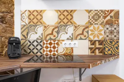 a store counter with a wall of tiles at BRAND NEW Pl Espana Sants Fira Apartment 2024 Built, Aplus, AirCon & Heating, Gigabit WiFi, Parking in Barcelona