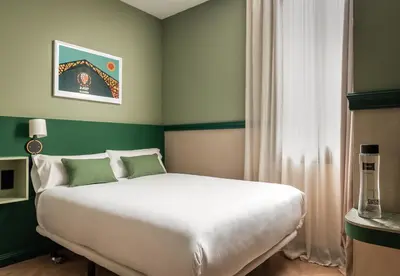 a bedroom with a large white bed and green walls at BYPILLOW Twenty in Barcelona