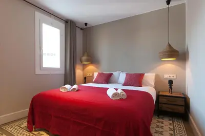 a bedroom with a large red bed with towels on it at Weflating Suites Sant Antoni Market in Barcelona