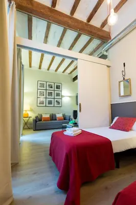 a bedroom with two beds and a couch in a room at Weflating Suites Sant Antoni Market in Barcelona