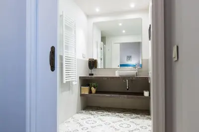 a bathroom with a sink and a mirror at Weflating Suites Sant Antoni Market in Barcelona