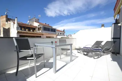 a patio with a table and chairs on a roof at Viva Sitges - Mayo Terrace in Sitges