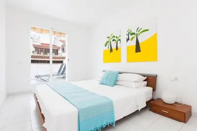 a white bedroom with a bed and a window at Viva Sitges - Mayo Terrace in Sitges