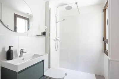 a white bathroom with a sink and a shower at Modern 1 bedroom apartments near Parallel in Barcelona