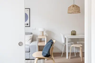 a living room with a table and a chair with a pillow on it at Modern 1 bedroom apartments near Parallel in Barcelona