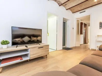 a living room with a flat screen tv on a wooden entertainment center at Apartment Eixample Dret Aragó Roger de Lluria by Interhome in Barcelona