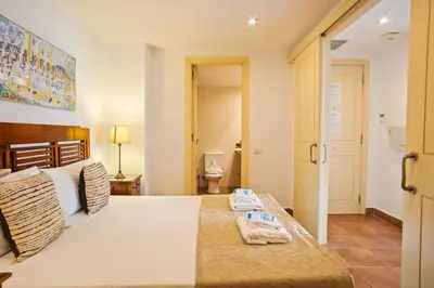 a bedroom with a bed with two towels on it at Alcam Dali in Barcelona