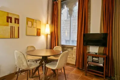 a dining room with a table and chairs and a television at Alcam Dali in Barcelona