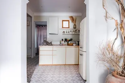 a kitchen with white cabinets and a refrigerator at Canela Homes BARCELONA PERMANYER in Barcelona