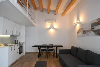 a living room with a table and a couch at Homenfun Dalt Badalona in Badalona