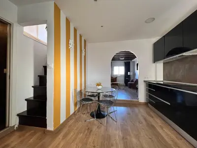 a kitchen with a table and a yellow and white wall at Diamond Rooftop & private terrace sea views in Barcelona