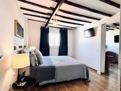 a bedroom with a bed with a blue comforter at Diamond Rooftop & private terrace sea views in Barcelona