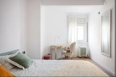 a white bedroom with a bed and a desk at 2 Habitaciones Hospitalet in Hospitalet de Llobregat