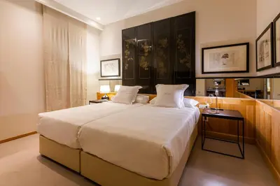 a bedroom with a large white bed and a table at Hotel Margot House Barcelona in Barcelona