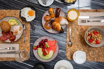 a table with plates of breakfast food on it at Hotel Margot House Barcelona in Barcelona