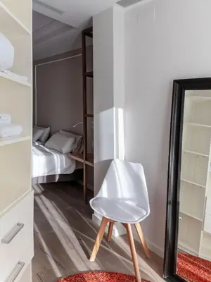 a white chair in a room with a bedroom at Rental Apartment Barcelona in Barcelona