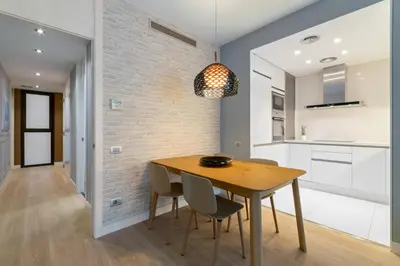 a kitchen and dining room with a wooden table and chairs at Tendency Rambla Catalunya in Barcelona