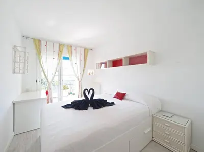 a white bedroom with a bed with a ribbon on it at BCN | Duplex Penthouse & Pool in Sant Andreu de Llavaneres
