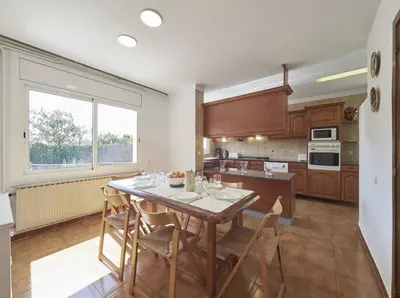 a kitchen with a table and chairs in a room at Villa Julia | 14pax. 5' sea & train in Sant Andreu de Llavaneres