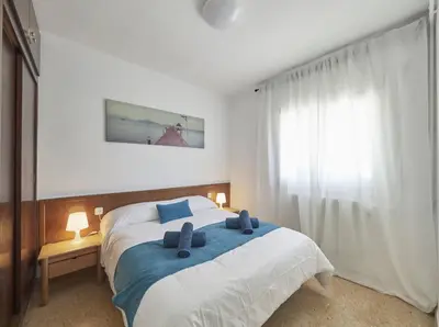 a bedroom with a large bed with a blue blanket at Villa Julia | 14pax. 5' sea & train in Sant Andreu de Llavaneres