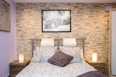 a bedroom with a bed with a brick wall at Vacarisses- Torreblanca Estacin in Vacarisas