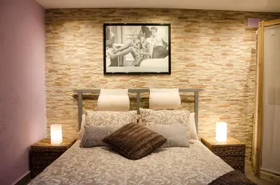 a bedroom with a bed with a brick wall at Vacarisses- Torreblanca Estacin in Vacarisas