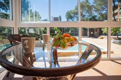 a glass table with a bowl of fruit on it at Elis house Piscina Privada Villa Mediterránea in Castelldefels