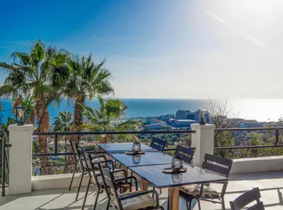a table and chairs on a balcony overlooking the ocean at Bluehillsitges - Only Adults in Sitges