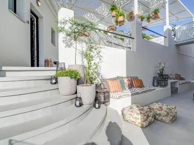 a living room with white stairs and potted plants at Bluehillsitges - Only Adults in Sitges