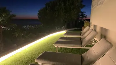 a row of lounge chairs on the side of a building at Bluehillsitges - Only Adults in Sitges