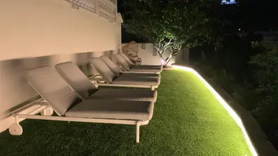 a row of chairs sitting on a lawn at night at Bluehillsitges - Only Adults in Sitges