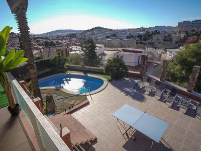 a view of a swimming pool with chairs and a table at Bed BCN Hills House in Barcelona