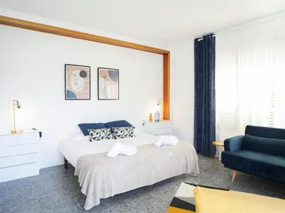 a bedroom with two beds and a blue couch at Bed BCN Hills House in Barcelona