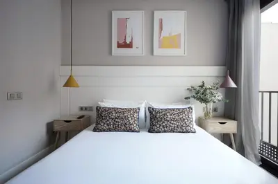 a bedroom with a large white bed with two pillows at Numa Barcelona Brio in Barcelona