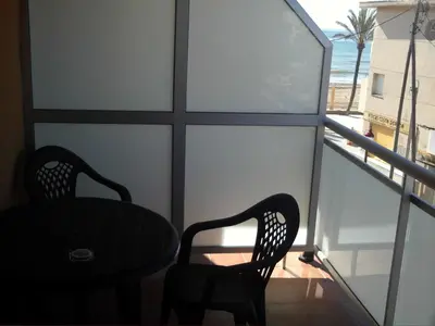 a balcony with two chairs and a table and a window at Hostal Cubelles in Cubelles
