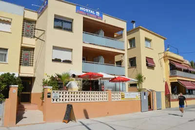 a building with a restaurant in front of it at Hostal Cubelles in Cubelles